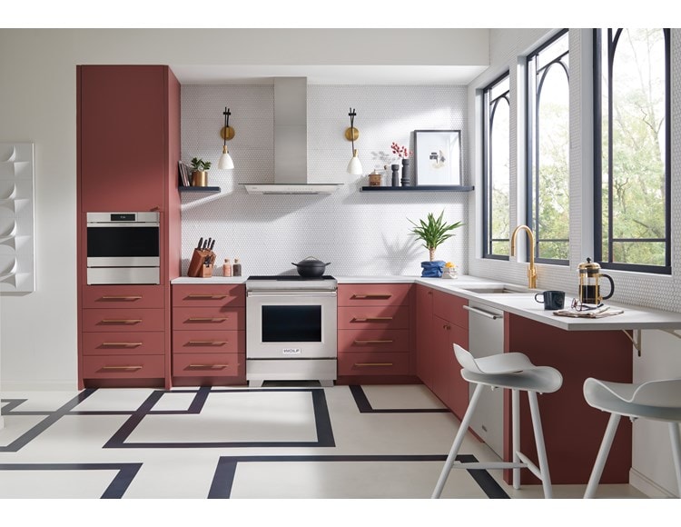 Cuisinière à induction Wolf 30/34 de style professionnel (IR30450/S/P) présentée dans la cuisine à armoires saumon avec revêtement de sol géométrique.