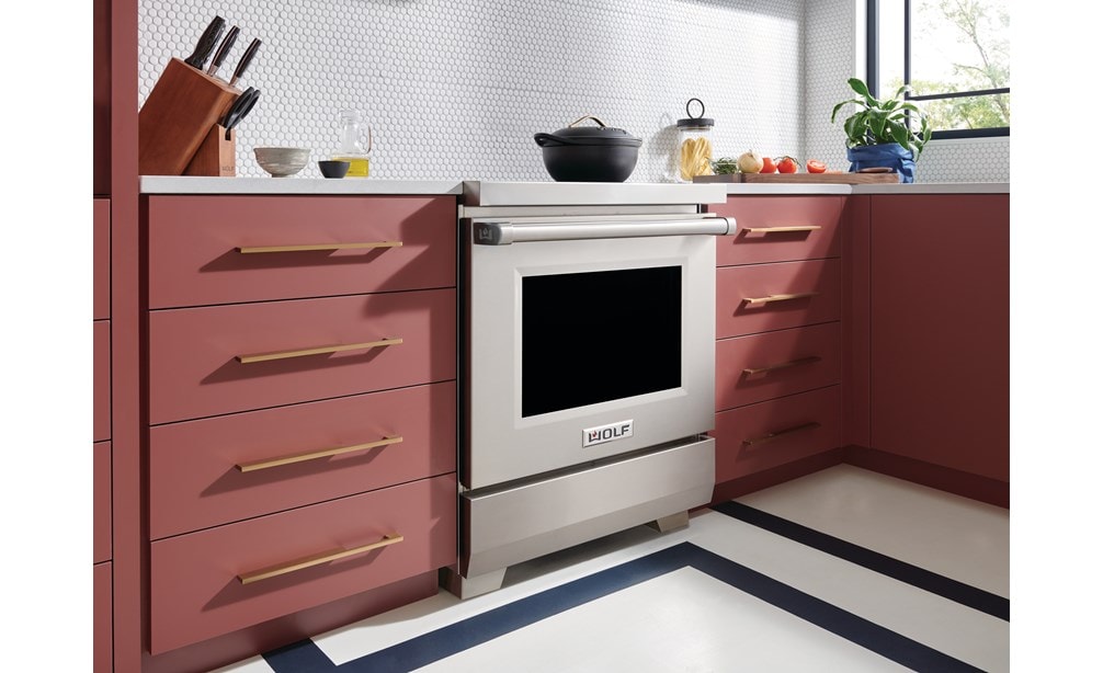 Wolf 30" Professional Induction Range (IR30450/S/P) featured in salmon cabinetry kitchen with a matte black covered pot on its surface.