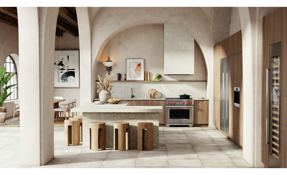 Wolf Professional Induction Range with iconic red knobs shown in a modern bohemian kitchen design featuring an arcade of tall arch walls with matching l-shaped kitchen island.