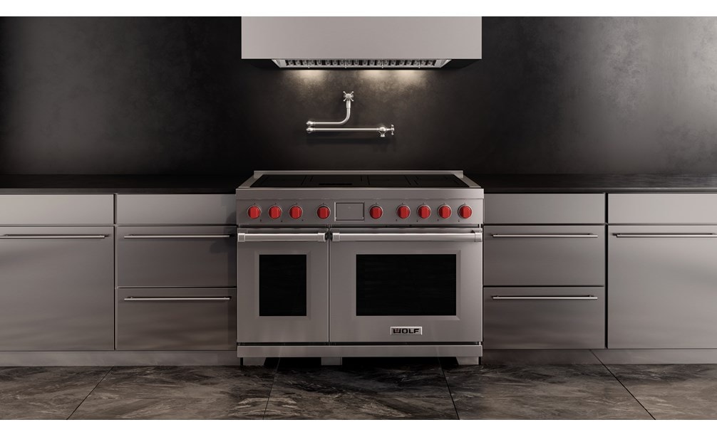 Wolf Professional Induction Range with stainless accent oven door shown here with a Wolf Professional Hood Liner in a minimalist  kitchen design featuring matching stainless kitchen cabinet handles.