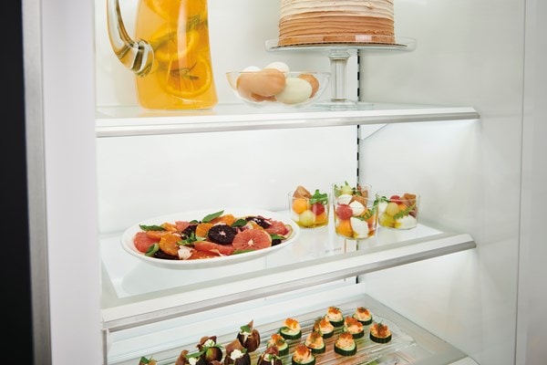 Close up view of Sub-Zero Classic Series Full Size Refrigerator's LED lit  custom shelves
