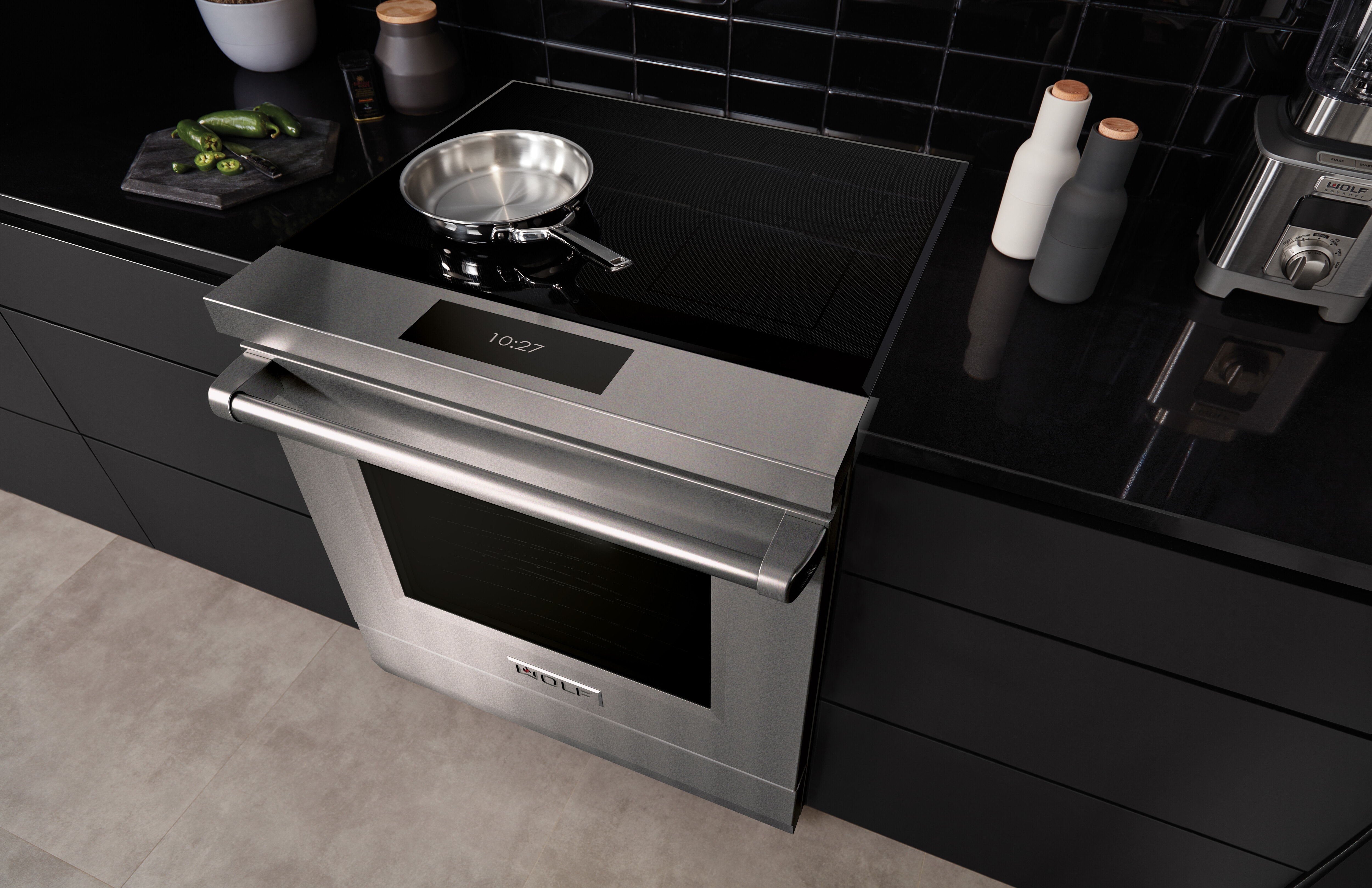 La surface de cuisson à induction moderne de 36 po de Wolf (CI36560T), avec son élégante surface en verre noir épuré, s'intègre en affleurant parfaitement dans cette cuisine contemporaine à l'ambiance méditerranéenne.