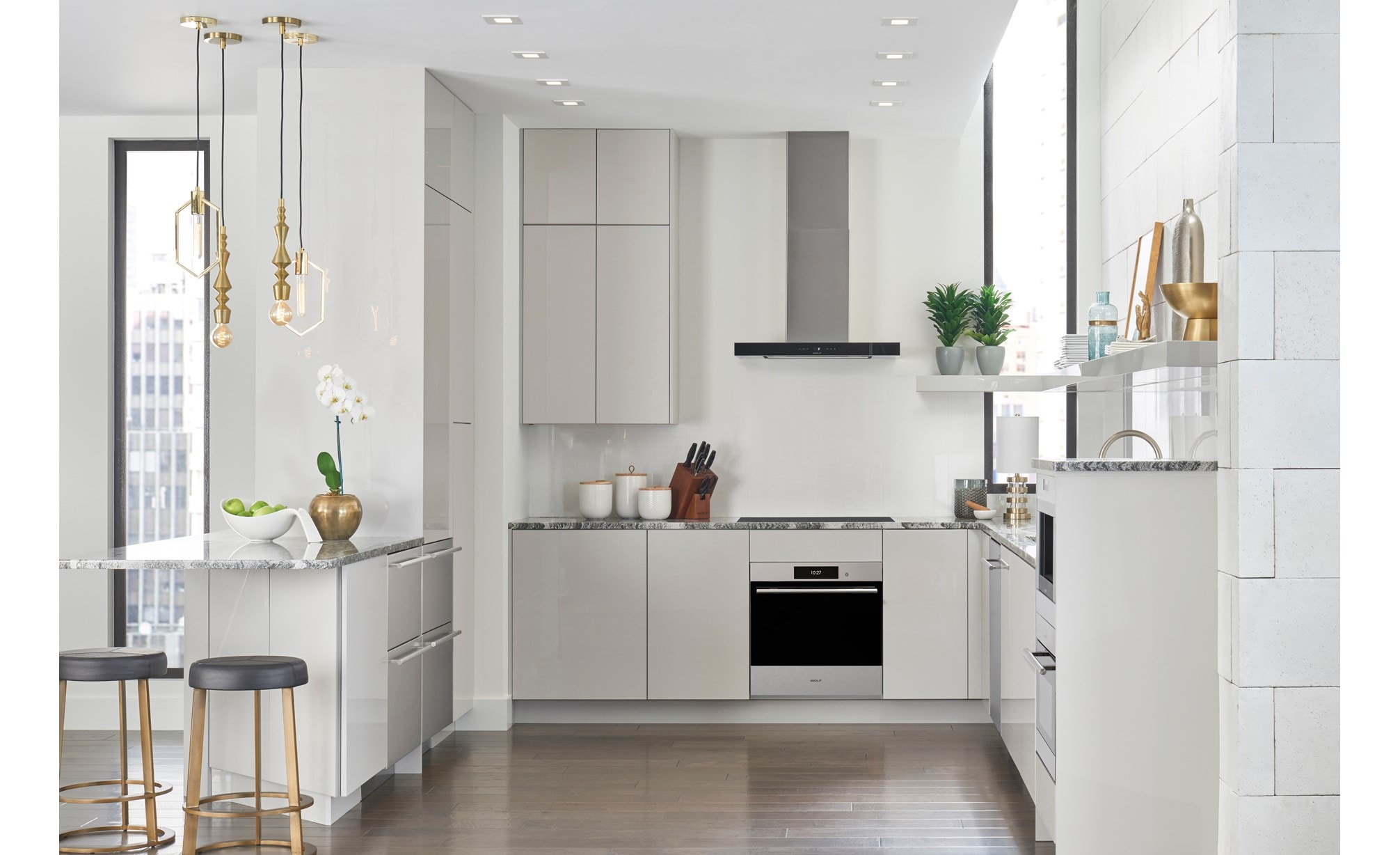 Surface de cuisson à induction Wolf 30 po de style contemporain (CI30460C/B) présentée ici dans un design de cuisine de petit espace avec des armoires blanches lisses sans poignée et des comptoirs en marbre