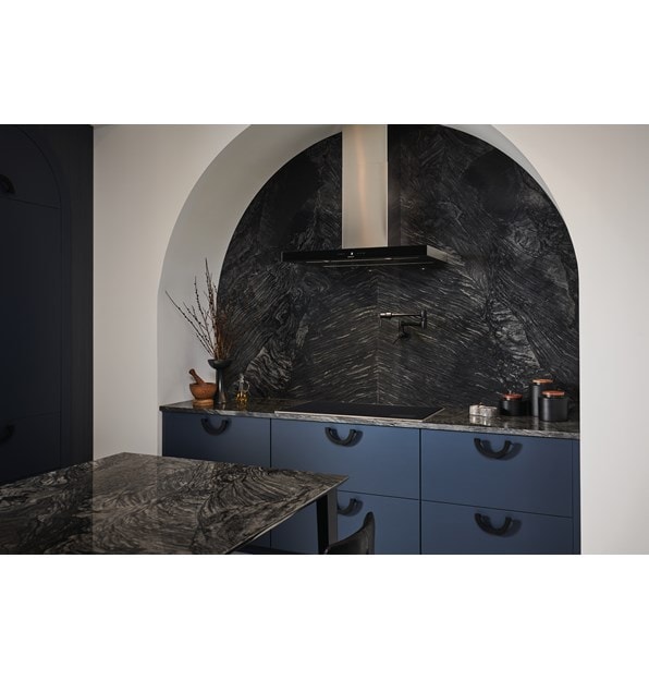 La surface de cuisson à induction Wolf 36 po de style transitionnel (CI36560T/S) est présentée dans une enceinte de cuisson en marbre avec des tiroirs d'armoire bleus. 