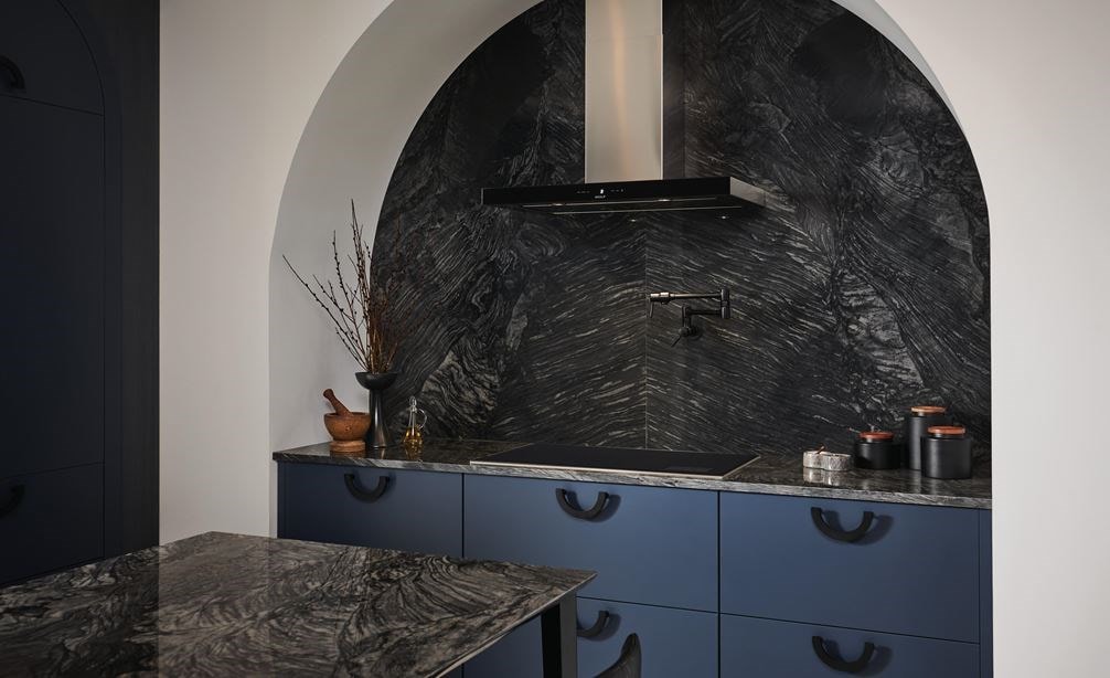La surface de cuisson à induction Wolf 36 po de style transitionnel (CI36560T/S) est présentée dans une enceinte de cuisson en marbre avec des tiroirs d'armoire bleus. 