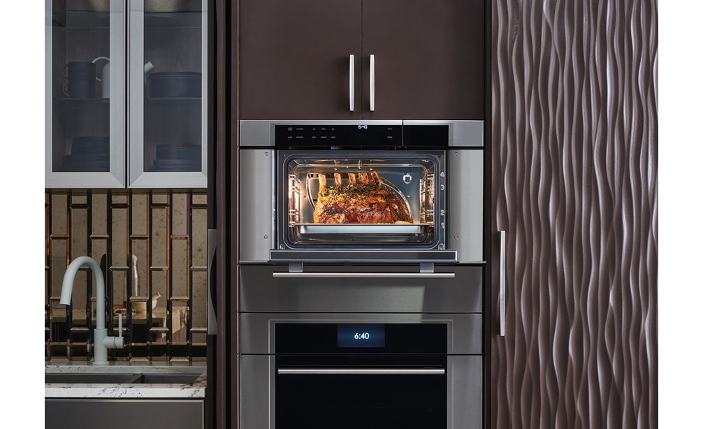 Four à convection-vapeur de style transitionnel Wolf Série M 30 po (CSO30TM/S/TH) présenté dans un agencement élégant d'armoires de cuisine chaudes et lisses