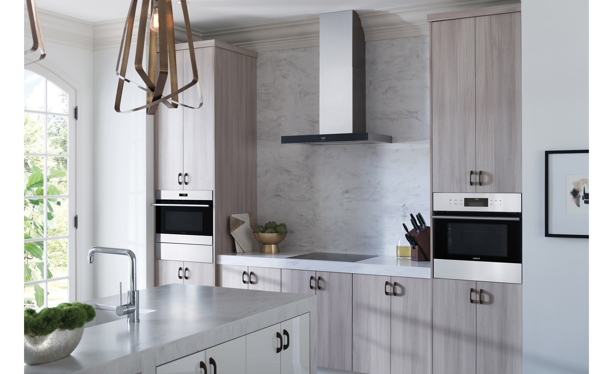 Hotte murale pour surface de cuisson Wolf 30 po - noire (VW30B) avec surface de cuisson à induction Wolf 24 po de style contemporain (CI243C/B) dans une cuisine spacieuse et lumineuse