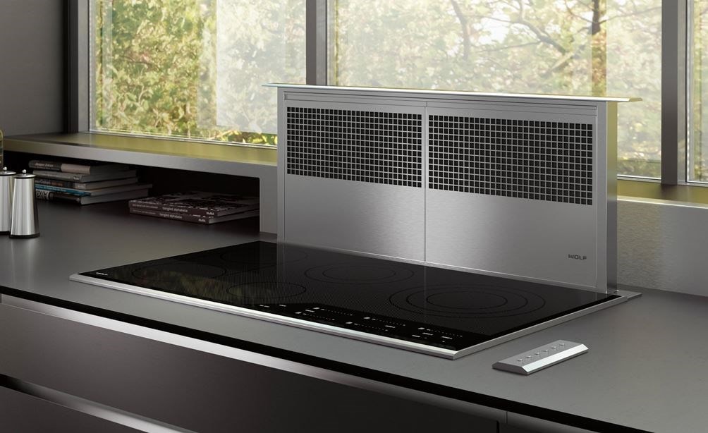 Ventilation à aspiration descendante Wolf 36 po (DD36) présentée avec une surface de cuisson électrique de style contemporain de 36 po (CE365C/B) dans une cuisine moderne luxueuse