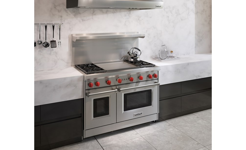 La cuisinière à gaz Wolf 48 po à 4 brûleurs avec plaque à frire double infrarouge (GR484DG) présentée dans un design de cuisine moderne épurée et minimaliste