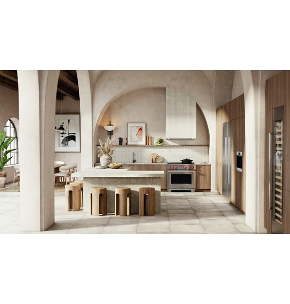 Wolf Professional Induction Range with iconic red knobs shown in a modern bohemian kitchen design featuring an arcade of tall arch walls with matching l-shaped kitchen island.