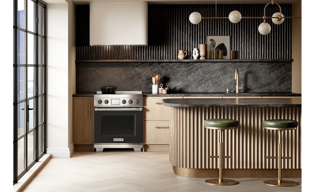Wolf 30 Inch Professional Induction Range featuring black accent oven door and knobs paired with a Wolf Professional Hood Liner are displayed in a sleek high rise kitchen design.